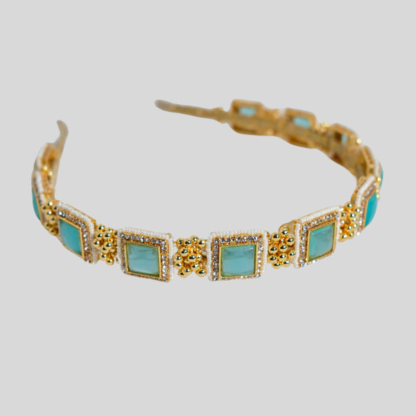 Elevate your hairstyle with the Turquoise Square Stone Hairband, a unique blend of elegance and modern charm. The hairband features a series of vibrant turquoise square stones, beautifully framed by gold detailing and delicate pearl accents. This intricate design offers a sophisticated touch, making it the perfect accessory for weddings, special events, or festive occasions. Crafted with attention to detail, this hairband combines contemporary style with traditional craftsmanship. The lightweight design ens